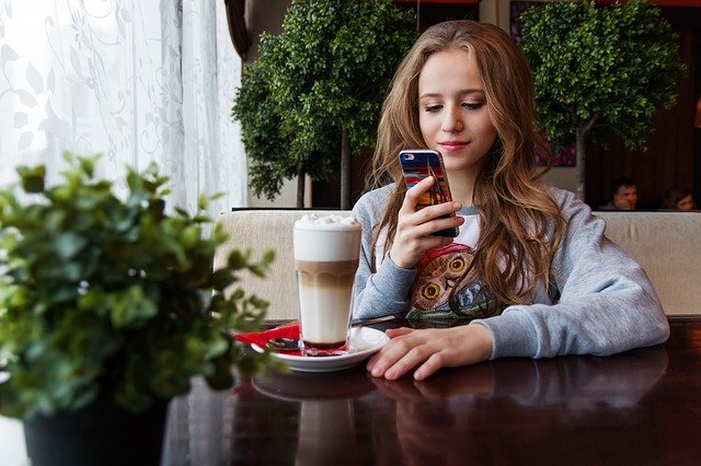 dívka na mobilním telefonu v kavárně.jpg
